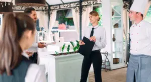 Hospitality staff gathered for a pre-service meeting in a restaurant.